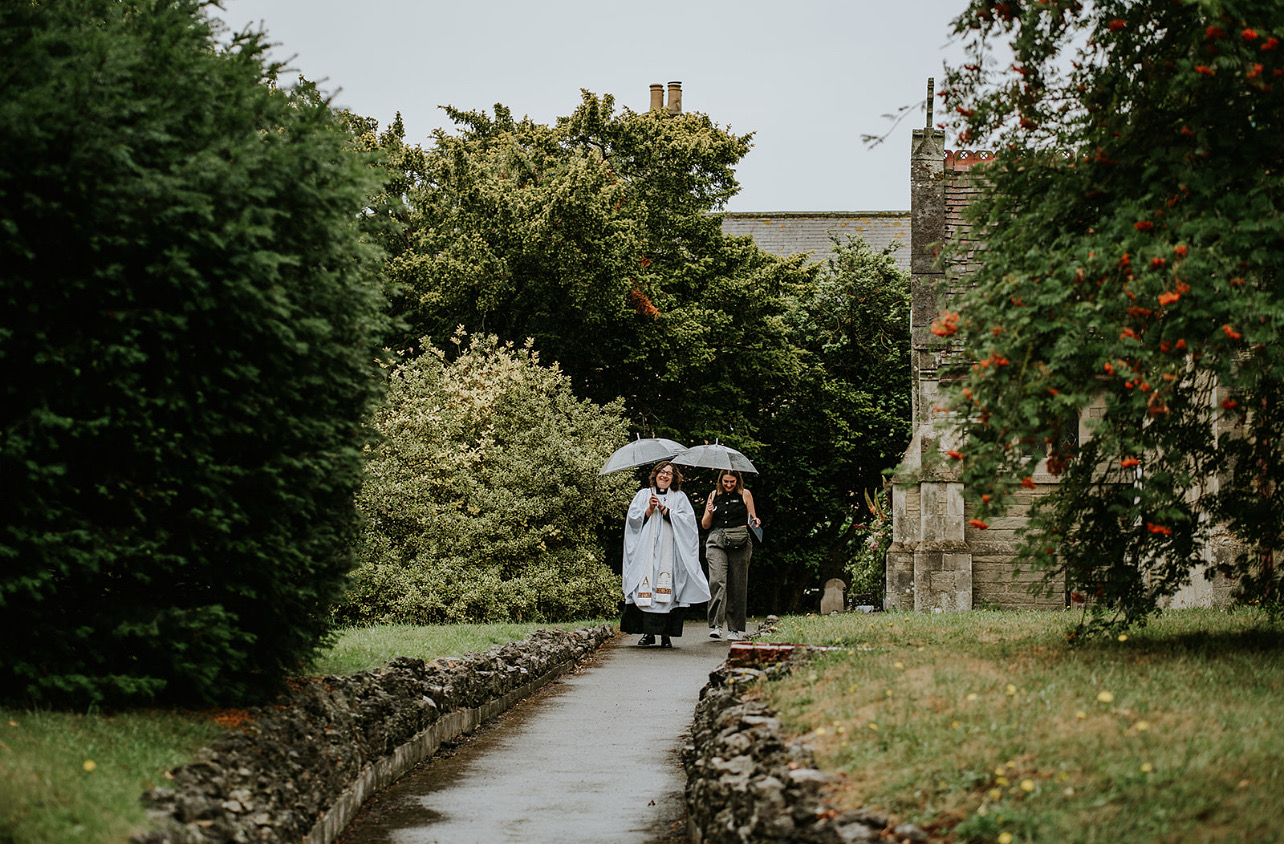 Couple walking together in the rain on their wedding day - Professional wedding co-ordination ensures your special day runs smoothly even in unexpected weather